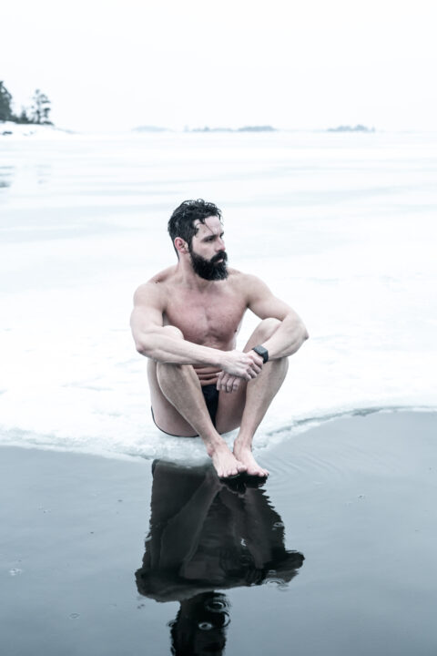 Man sitting by icy water in Helsinki